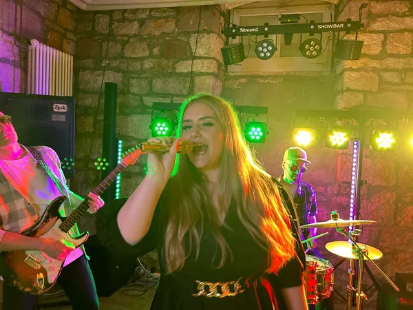BandScape Liveband mit Sängerin, Gitarrist und Schlagzeuger bei einem energiegeladenen Live-Auftritt für Events in der Schweiz.